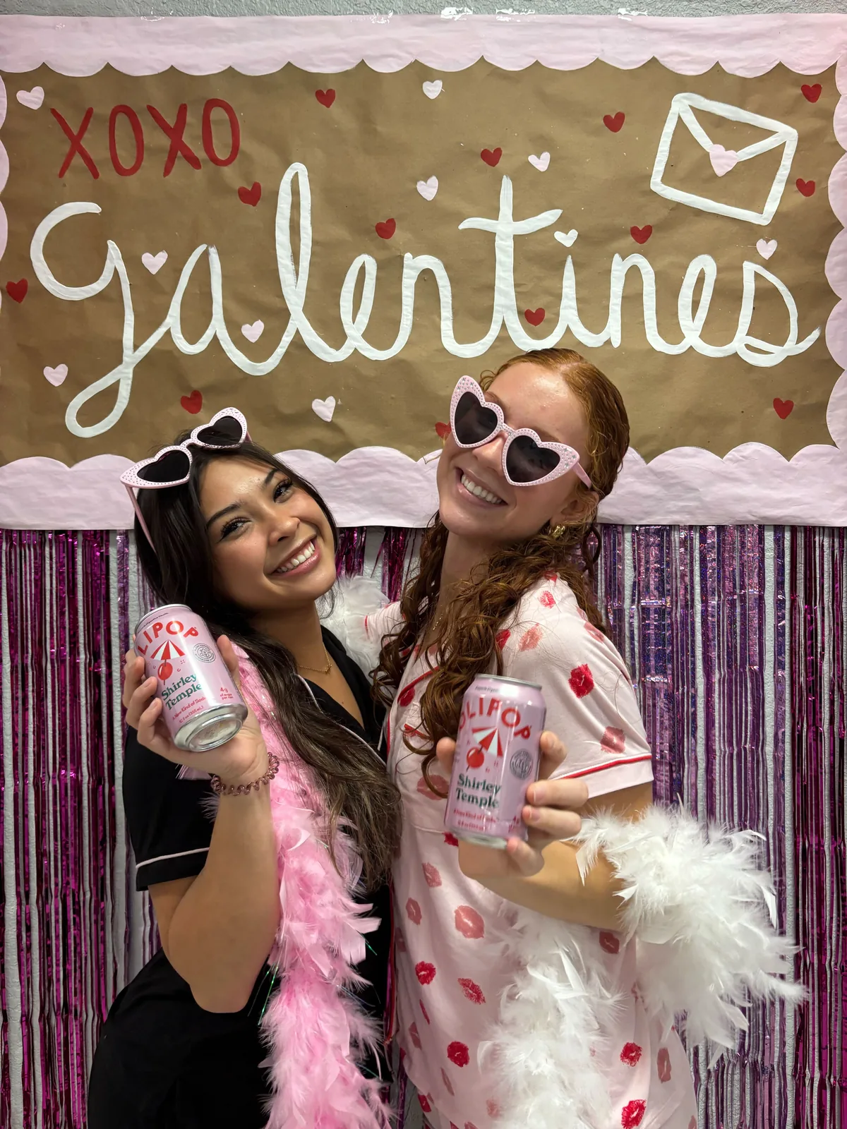 Two college students at a sorority Galentine's event holding OLIPOP Shirley Temple cans
